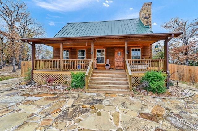 log-style house featuring covered porch