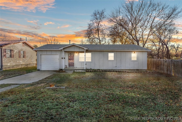 ranch-style house with a garage and a yard