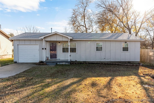 ranch-style house featuring a garage and a front lawn