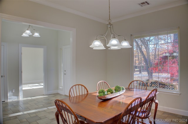 dining space with ornamental molding and an inviting chandelier