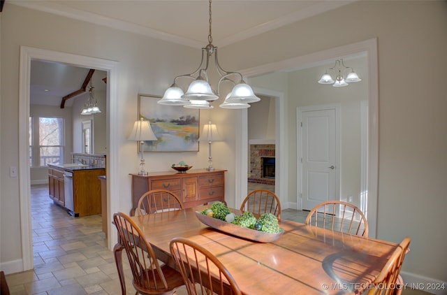 dining room featuring a notable chandelier and a brick fireplace