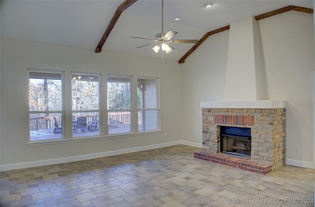 unfurnished living room with beamed ceiling, ceiling fan, high vaulted ceiling, and a brick fireplace