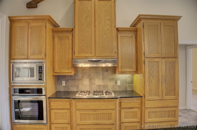 kitchen featuring dark stone counters, appliances with stainless steel finishes, and tasteful backsplash