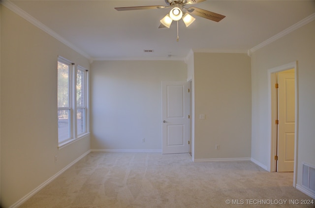 carpeted spare room with ceiling fan and ornamental molding