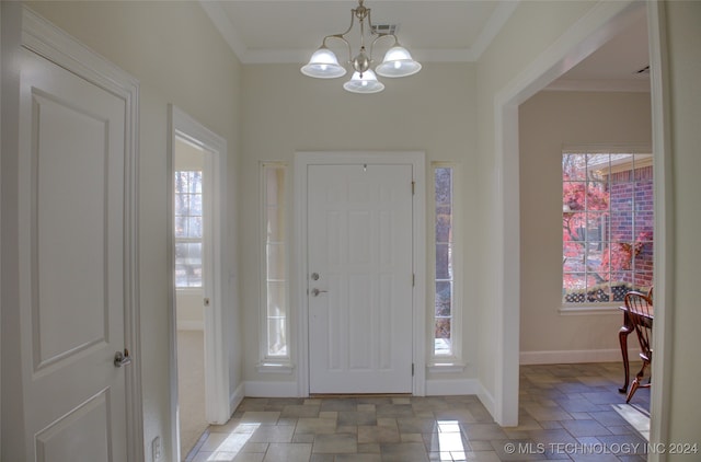 entryway with crown molding and an inviting chandelier