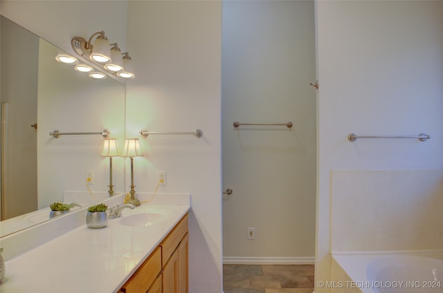 bathroom featuring a washtub and vanity