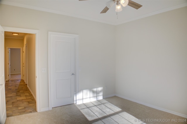 spare room featuring light carpet, ceiling fan, and ornamental molding