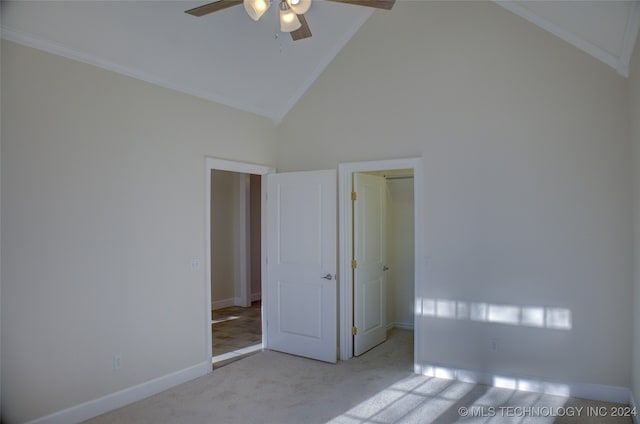 unfurnished bedroom with ceiling fan, crown molding, high vaulted ceiling, and light carpet