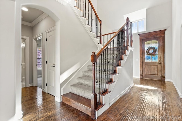 stairs featuring hardwood / wood-style floors and ornamental molding