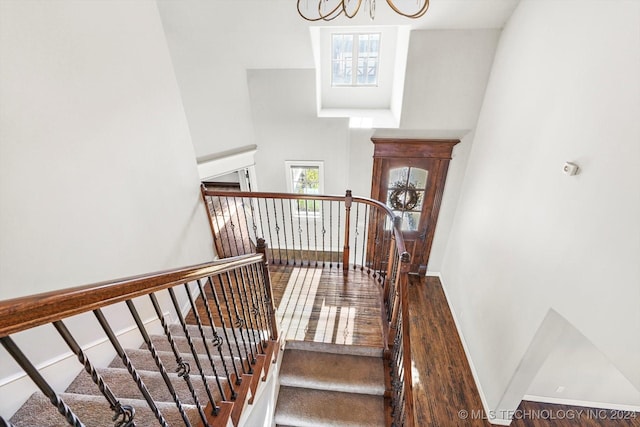 stairs featuring a notable chandelier and hardwood / wood-style flooring