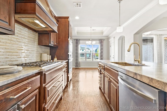 kitchen with appliances with stainless steel finishes, custom exhaust hood, dark wood-type flooring, sink, and pendant lighting