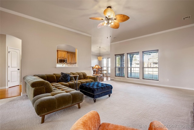 living room with ceiling fan, light colored carpet, and ornamental molding