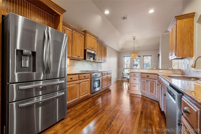 kitchen featuring dark wood-type flooring, sink, tasteful backsplash, decorative light fixtures, and stainless steel appliances