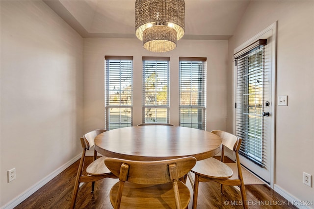 dining space featuring a notable chandelier, plenty of natural light, dark hardwood / wood-style flooring, and lofted ceiling