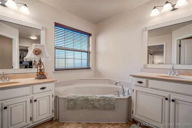 bathroom featuring tile patterned flooring, vanity, and a bath