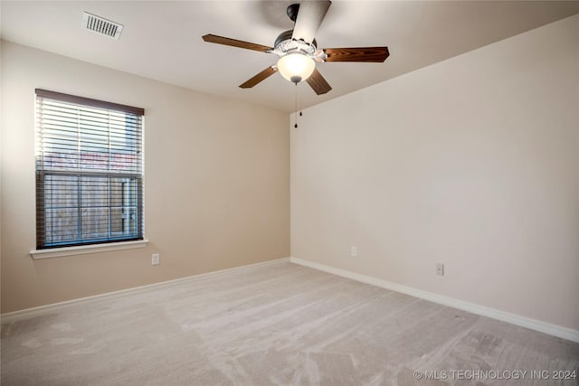 carpeted spare room featuring ceiling fan