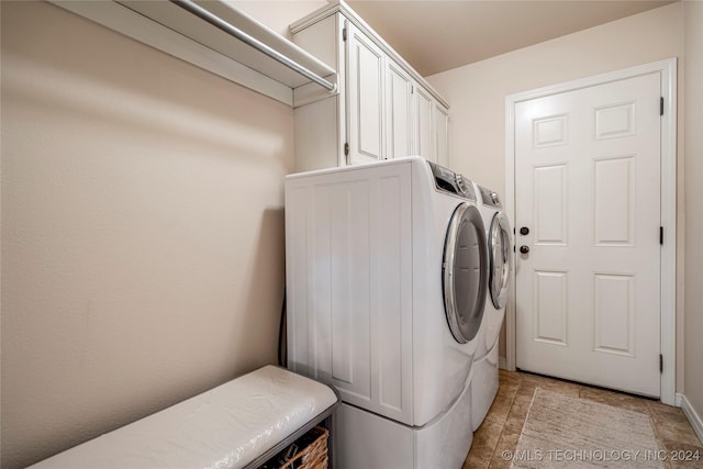 laundry area with washer and dryer and cabinets