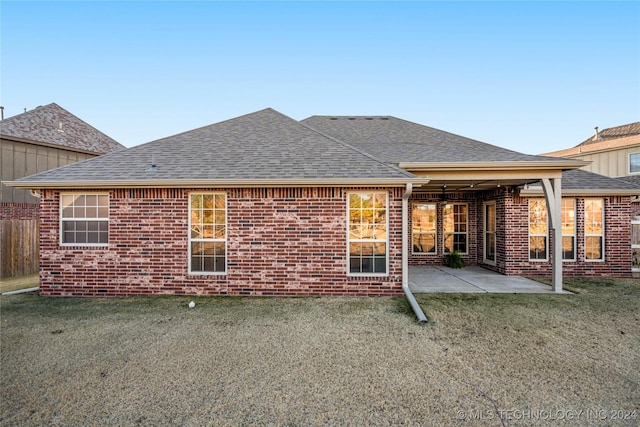 back of property with a patio and a lawn