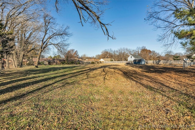 view of yard featuring a rural view and a storage shed