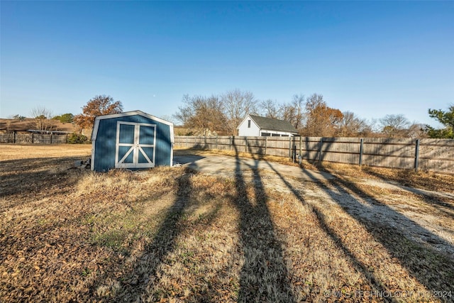 view of yard with a rural view and a storage unit