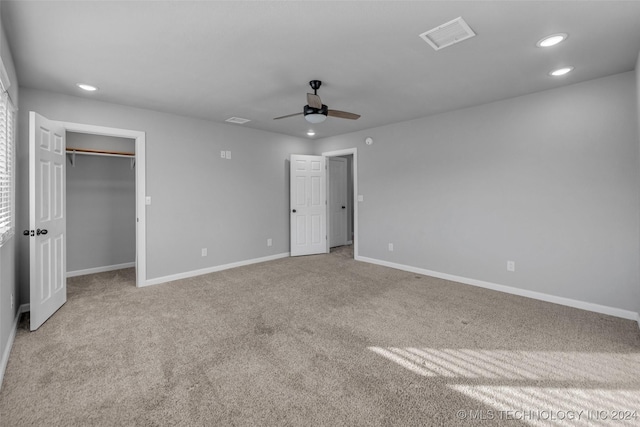 unfurnished bedroom featuring ceiling fan, light colored carpet, and a closet