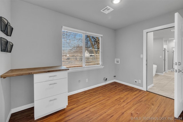 interior space with ensuite bath, light hardwood / wood-style flooring, and built in desk