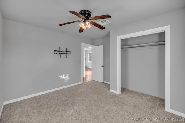 unfurnished bedroom featuring light carpet, a closet, and ceiling fan