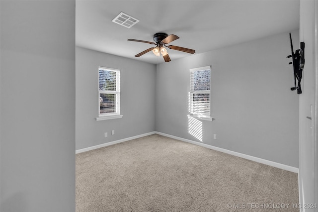 carpeted spare room featuring ceiling fan