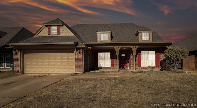 view of front of house featuring a porch, a garage, and a lawn