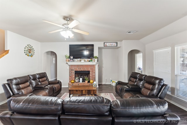 living room featuring hardwood / wood-style floors, ceiling fan, and a brick fireplace