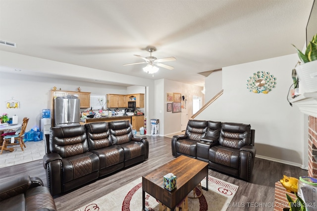 living room with a fireplace, hardwood / wood-style flooring, and ceiling fan