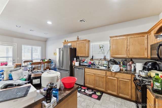 kitchen with black appliances, light tile patterned flooring, and sink