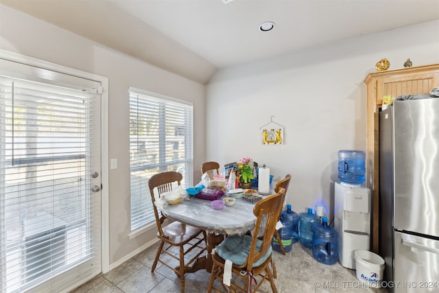 tiled dining space with lofted ceiling