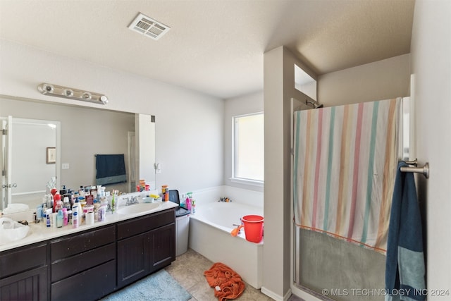 bathroom with separate shower and tub, vanity, and a textured ceiling