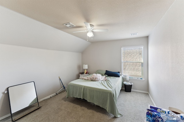 carpeted bedroom featuring ceiling fan, a textured ceiling, and vaulted ceiling