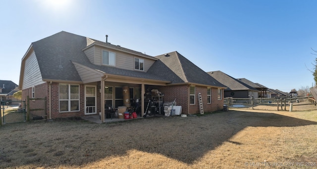 rear view of property with a yard and a patio area