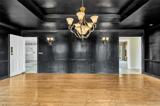 interior space featuring crown molding, hardwood / wood-style floors, and a chandelier