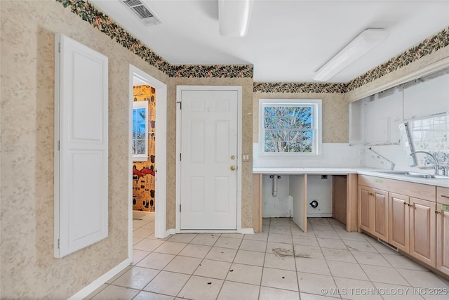 kitchen with decorative backsplash, sink, and light tile patterned floors