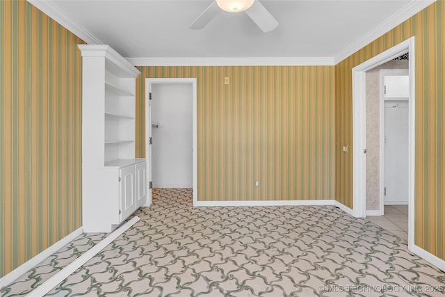 empty room with ceiling fan, built in shelves, and ornamental molding