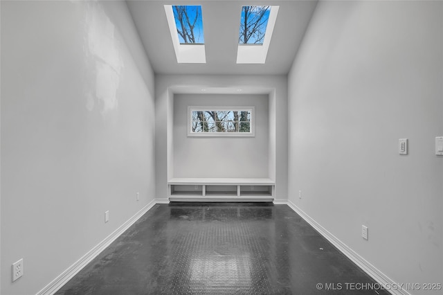 unfurnished room featuring a skylight