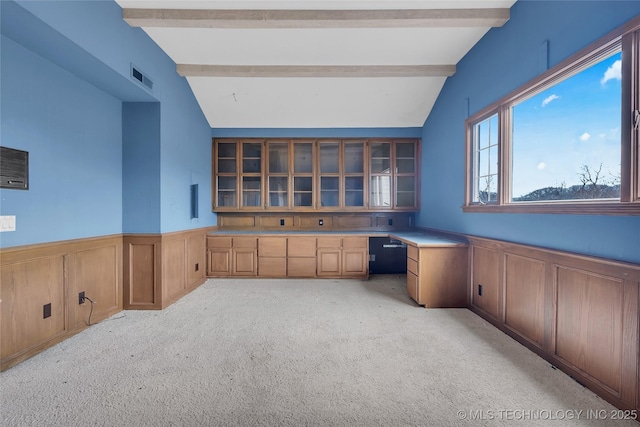 home office with built in desk, light carpet, and lofted ceiling with beams