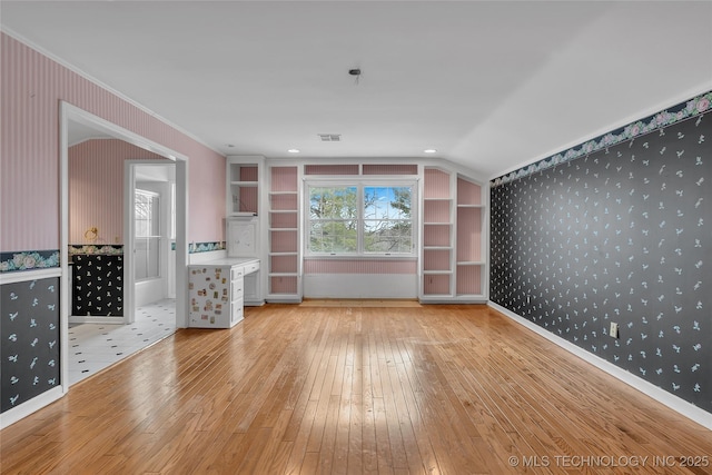 interior space with crown molding, light hardwood / wood-style flooring, and lofted ceiling