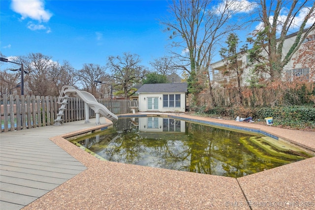 view of swimming pool with an outdoor structure and a water slide