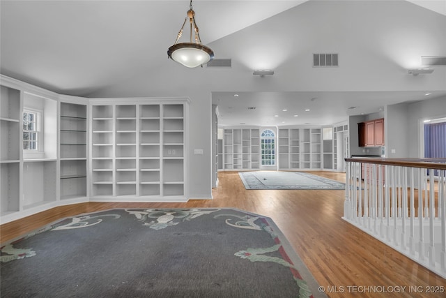 interior space with built in features, hardwood / wood-style flooring, and lofted ceiling