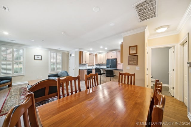 dining room featuring ornamental molding and light hardwood / wood-style flooring