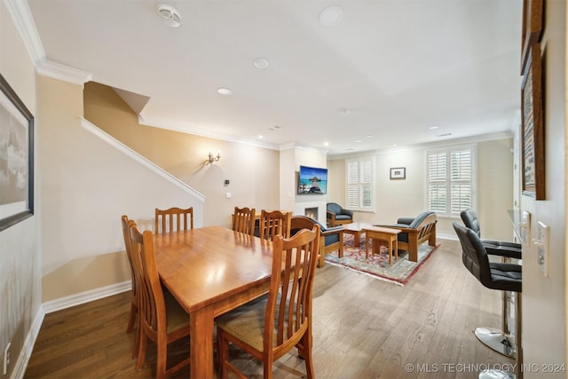 dining room featuring dark hardwood / wood-style flooring and crown molding