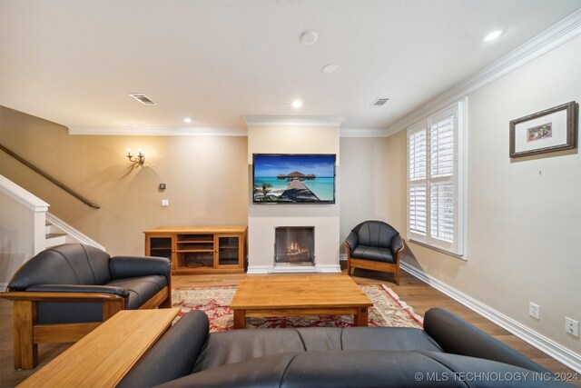 living room with wood-type flooring and crown molding