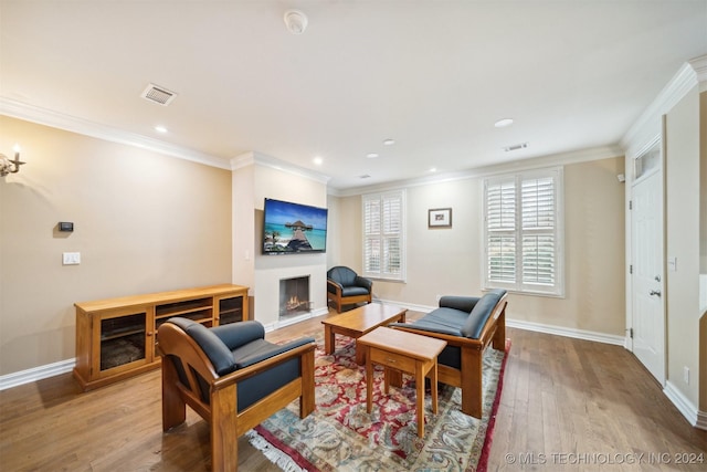 living room featuring light wood-type flooring and ornamental molding