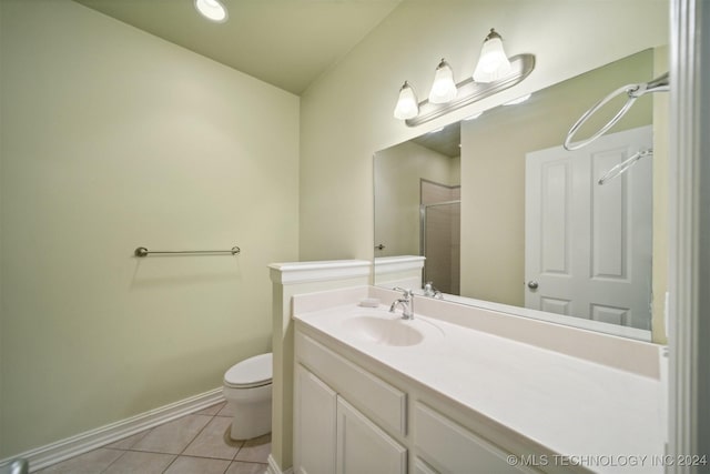 bathroom with tile patterned flooring, vanity, toilet, and an enclosed shower