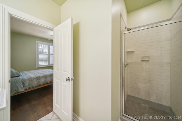 bathroom featuring a shower with shower door and hardwood / wood-style flooring